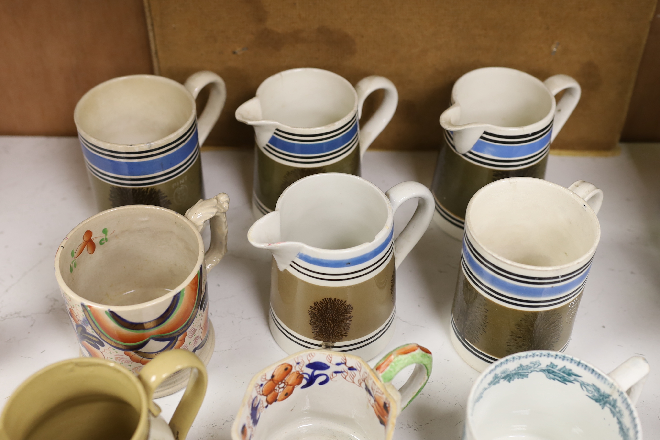 A group of Mocha ware, three various earthenware mugs, a Wemyss-style teapot, etc. (12)